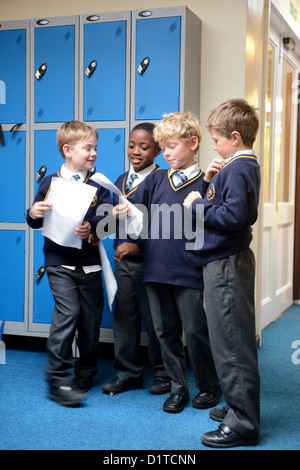 Les garçons en comparant leur travail à Notre Dame et St Werburgh's Catholic Primary School à Newcastle-under-Lyme Staffordshire, Royaume-Uni Banque D'Images