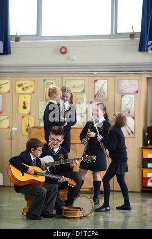 Les garçons pratiques sur leurs guitares au cours d'une leçon de musique Notre Dame et St Werburgh's Catholic Primary School à Newcastle-under-Lyme, Banque D'Images