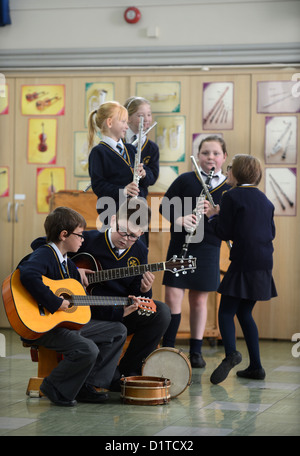 Les garçons pratiques sur leurs guitares au cours d'une leçon de musique Notre Dame et St Werburgh's Catholic Primary School à Newcastle-under-Lyme, Banque D'Images