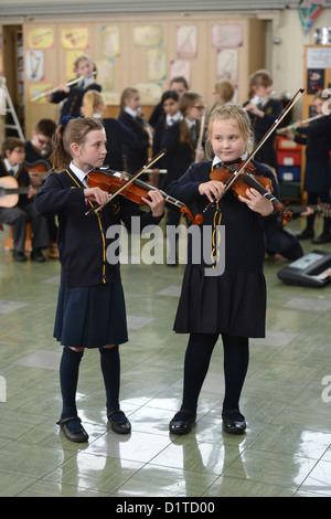 Deux jeunes filles jouant du violon dans une leçon de musique Notre Dame et St Werburgh's Catholic Primary School à Newcastle-under-Lyme, Staffords Banque D'Images