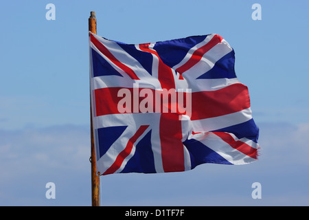 Drapeau britannique / Union Jack dans le vent contre un ciel bleu Banque D'Images