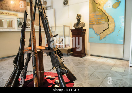 Musée d'histoire militaire du Vietnam armes à feu vintage enchaînées Hanoi Vietnam / HANOI, Vietnam — Centre d'armes à feu vintage enchaînées une galerie d'exposition à l'intérieur du Musée d'histoire militaire du Vietnam dans le district de Ba Đình. La carte de fond détaille la Révolution du 1945 août, le soulèvement qui a permis au Viet Minh de prendre le contrôle politique initial. Au cours de la première guerre d'Indochine de 1946 à 1954, les combattants indépendantistes s'appuyaient fortement sur les armements coloniaux français capturés pour mener leur campagne contre les forces coloniales. Banque D'Images