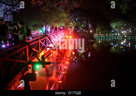 HANOI, Vietnam — les lumières du pont Huc (pont de la lumière du soleil du matin) et le rivage la nuit. Le pont en bois peint en rouge relie la rive nord du lac à l'île de Jade et au temple de la montagne de Jade (temple Ngoc son). Banque D'Images