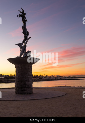 Statue de sirène jouant de la flûte par artiste inconnu à l'entrée du port de Ventura au lever du soleil Banque D'Images