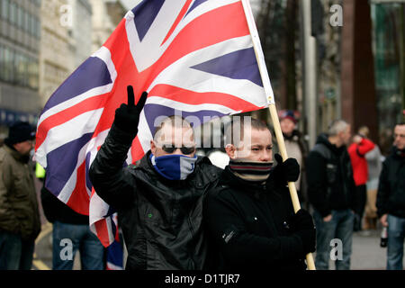 Belfast, Royaume-Uni. 5Th Jan, 2013. Deux hommes avec des foulards cachant leurs visages étaient partiellement au drapeau des protestations qui ont eu lieu à Belfast après le Conseil municipal a voté le 3 décembre 2012 pour restreindre le battant Union Jack flag à partir de l'hôtel de ville pour 17 jours par an, là où auparavant il a volé tous les jours de l'année. Banque D'Images