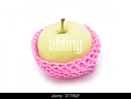 La pomme verte dans l'emballage rouge isolé sur fond blanc. Banque D'Images