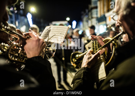 Laiton ou argent un groupe jouant de la musique de Noël Noël, en plein air, nuit, UK Banque D'Images