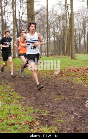 Kent Championnats de cross-country de moins de 17 jeunes garçons s'exécutant sur le chemin du sentier à travers le bois dans le brouillard et les conditions brumeuses Banque D'Images