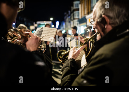 Laiton ou argent un groupe jouant de la musique de Noël Noël, en plein air, nuit, UK Banque D'Images