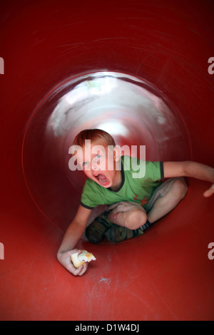 Berlin, Allemagne, garçon lentement à un tunnel sur une aire de jeux Banque D'Images