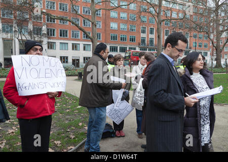 Londres, samedi 5 janvier, 2013. L'allumage des bougies à Mahatma Gandhi Memorial Statue, Tavistsock London-Save Square Garden de nos Sœurs. Les manifestants se sont réunis au Jardin Tavistock Square pour protester et montrer leur solidarité face à l'incident qui a eu lieu à Delhi, la capitale indienne, où une femme a été violée et jeté hors de l'autobus en mouvement à mourir. Le NRI indiens à Londres veulent une réponse du Gouvernement indien pour ce qui est arrivé. Un homme tenant une playcard tandis que d'autres hommes de la lecture de la pétition qui sera soumis à la Haute Commission indienne, Londres. Banque D'Images