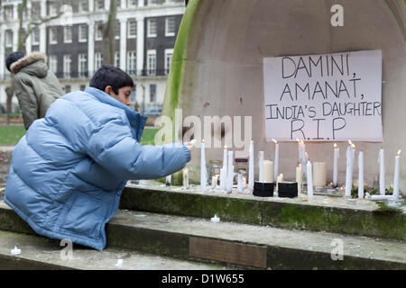 Londres, samedi 5 janvier, 2013. L'allumage des bougies à Mahatma Gandhi Memorial Statue, Tavistsock London-Save Square Garden de nos Sœurs. Les manifestants se sont réunis au Jardin Tavistock Square pour protester et montrer leur solidarité face à l'incident qui a eu lieu à Delhi, la capitale indienne, où une femme a été violée et jeté hors de l'autobus en mouvement à mourir. Le NRI indiens à Londres veulent une réponse du Gouvernement indien pour ce qui est arrivé. Un enfant vu allumer une chandelle sous le Mahatma Gandhi Statue. Banque D'Images