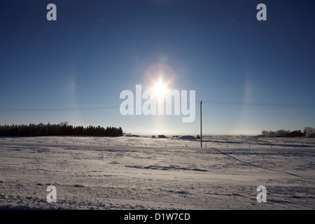 Paire de halo sun dog parhelion due à des cristaux de glace entourant le soleil en Saskatchewan Canada Banque D'Images