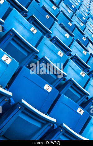 Sièges repliés bleu dans un stade (détails, arrière-plan) Banque D'Images