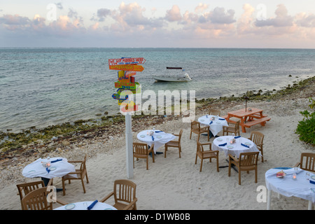 Plage au bord de l'eau, tables de restaurant, Tukka est de Grand Cayman, Cayman Islands, British West Indies Banque D'Images
