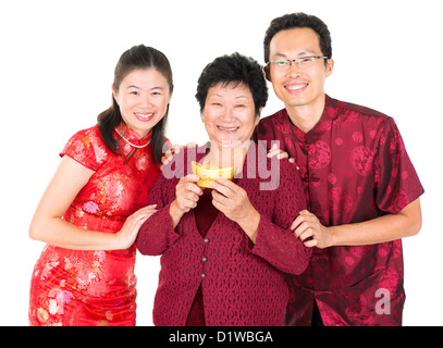 Joyeux Nouvel An chinois. La famille chinoise asiatique accueil, tenant un lingot d'or isolé sur fond blanc Banque D'Images