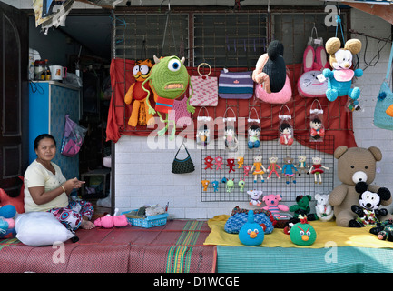 Femme thaïlandaise affichant des enfants fait main soft toys à vendre à l'extérieur de sa maison. Thaïlande personnes qui travaillent à domicile. S. E. l'Asie Banque D'Images