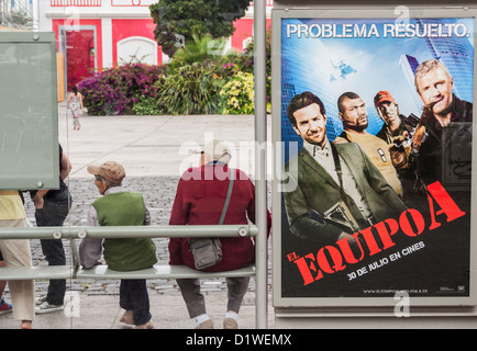 Deux personnes âgées hommes espagnol à côté de l'el Equipo A (l'équipe en espagnol) affiche de film à l'arrêt de bus en Espagne Banque D'Images