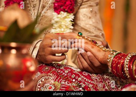 Close-up of a groom mettant un anneau de mariage sur une mariée Banque D'Images