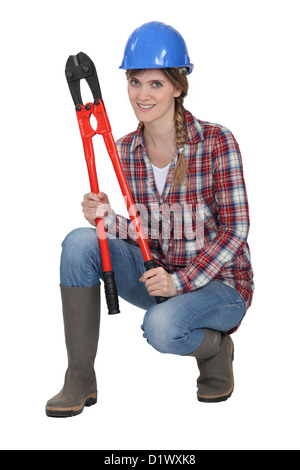 Woman crouching with bolt cutters Banque D'Images