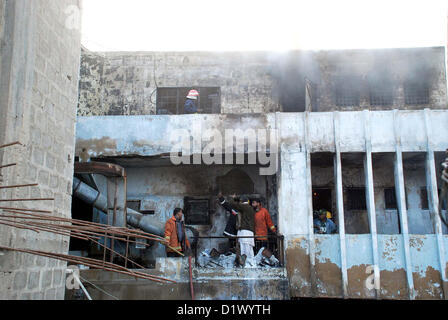 Les pompiers d'éteindre le feu dans une usine chimique qui a pris feu en raison de l'explosion chimique pendant les heures de travail, dans la zone industrielle de Korangi à Karachi le lundi, Janvier 07, 2013. Banque D'Images