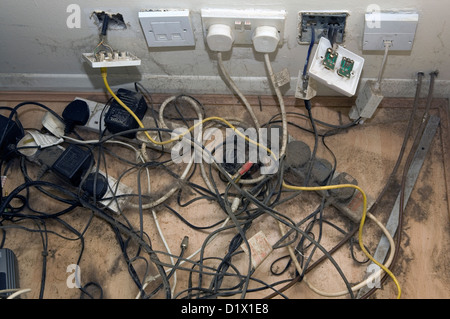 Câbles d'alimentation et poussiéreux des prises électriques dans un ménage. Banque D'Images