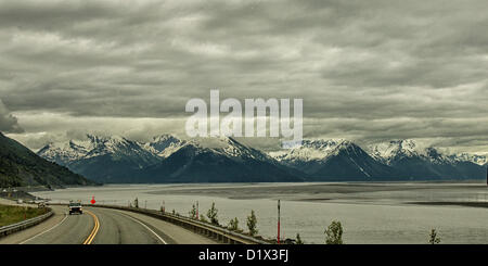 29 juin 2012 - péninsule de Kenai, Alaska, Etats-Unis - conduite au sud, pittoresque Seward Highway longe la base de la Chugach Mountains [gauche] et offre des vues spectaculaires sur les glaciers, montagnes aux montagnes Kenai encadrée par les formations de nuages spectaculaires. Ils s'élèvent au loin au-dessus de Turnagain Arm, à marée basse, ses eaux juste couvrant la baie. Une forêt nationale désignée Scenic Byway, un All-American Road et un Scenic Byway, l'ALASKA Seward Highway exécute 127 miles [204 km] de mouillage à Seward à travers la péninsule Kenai Chugach State Park, la Forêt Nationale de Chugach et, une vitrine des produits de beau Banque D'Images