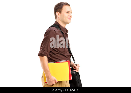 Un étudiant avec sac d'épaule holding books et la marche à pied isolé sur fond blanc Banque D'Images