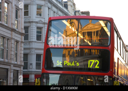 London, Greater London, Angleterre. La Cathédrale St Paul reflète dans de fenêtre rouge traditionnel double-decker bus, le coucher du soleil. Banque D'Images