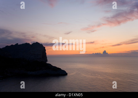 Port de Pollença, Majorque, Iles Baléares, Espagne. Ciel rose sur la Méditerranée après le coucher du soleil, la péninsule de Formentor. Banque D'Images