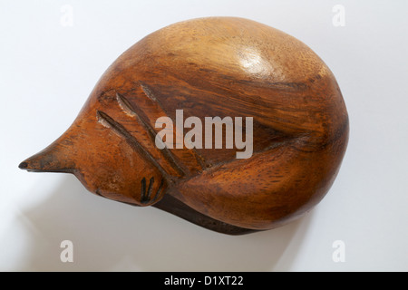 Recroquevillée sleeping cat sculpture en bois isolé sur fond blanc Banque D'Images