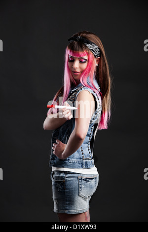 Portrait d'une jeune fille punk avec une belle coupe de cheveux en rose un tatouage dessin Banque D'Images