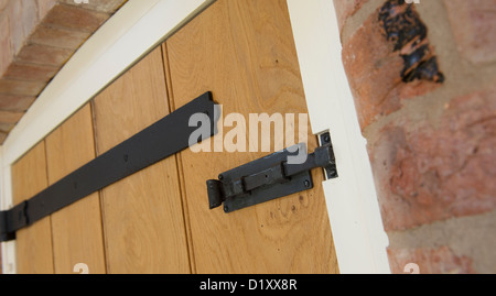Charnières en fonte noire et sur une nouvelle porte dans une propriété nouvellement construite. Banque D'Images