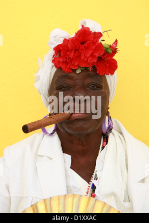 Santeria cubaine femme portant une robe blanche de fumer un gros cigare havane Cuba La Habana Vieja Banque D'Images