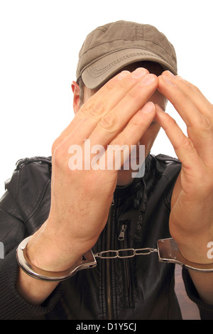 Homme avec menottes en face de son visage Banque D'Images