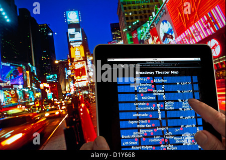 BROADWAY MAP iPad` THÉÂTRES mains tenant le Tablet ordinateur à la tombée de la nuit Dans Times Square affichant la carte de l'emplacement des théâtres de Broadway Manhattan New York, États-Unis Banque D'Images