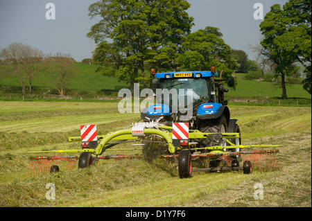 Close up of Claas râteau à herbe à l'œuvre dans le champ de l'ensilage. Northumberland, UK Banque D'Images