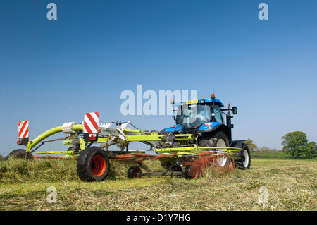 Close up of Claas râteau à herbe à l'œuvre dans le champ de l'ensilage. Northumberland, UK Banque D'Images