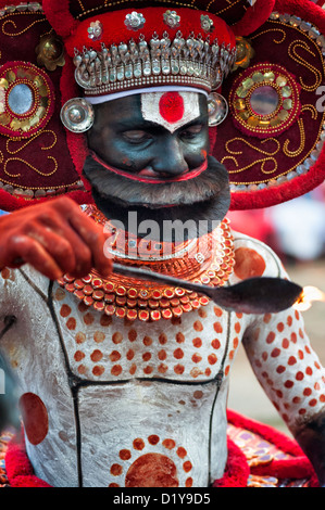 Les feux de l'artiste Theyyam flamme de cérémonie lors d'une performance dans un temple près de Thottada, Kannur, Kerala, Inde. Banque D'Images