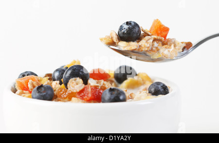 Un plan macro de muesli avec des bleuets frais, fruits secs, et le lait Banque D'Images