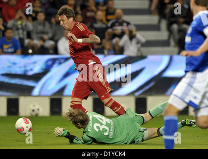 Le gardien de Schalke Timo Hildebrand (ci-dessous) convoite la la balle avec Munich, Mario Mandzukic lors d'un test match entre le FC Schalke 04 et le FC Bayern Munich à Jassim Bin Hamad Stadium à Doha, Qatar, 08 janvier 2013. Schalke va rester à leur camp d'entraînement d'hiver au Qatar jusqu'au 11 janvier 2013. Mouches Bayern retour à l'Allemagne le 09 janvier 2013. Photo : PETER KNEFFEL Banque D'Images