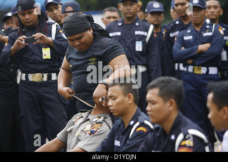 9 janvier 2013 - Solo, Central Java, Indonesia - 9 janvier 2013 - Solo, Central Java, Indonésie - un garde de sécurité montre la puissance d'être à l'abri se tranchant la gorge avec une machette au cours d'une cérémonie pour marquer le 32e anniversaire de l'organisation de gardes de sécurité civile le 9 janvier 2013 en Solo, le centre de Java, en Indonésie. Les agents de sécurité de l'Indonésie sont utilisés par des sociétés privées pour assurer la sécurité des organisations comme les banques, les bureaux, les écoles et autres. (Crédit Image : Crédit : Sijori Images/ZUMAPRESS.com/Alamy Live News) Banque D'Images