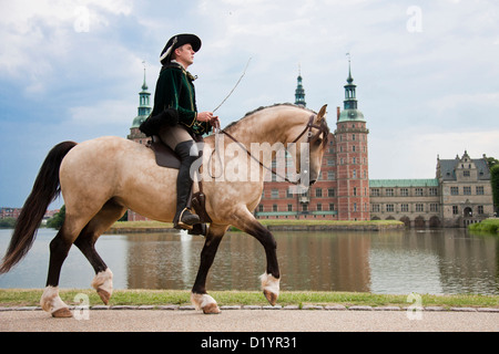 Frederiksborger avec rider en costume historique trotting en face de Frederiksborg Palace, Danmark Banque D'Images