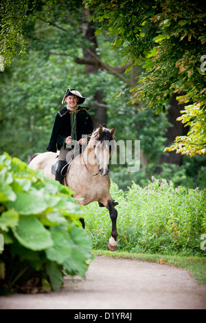 Frederiksborger avec rider en costume historique trottant dans le jardin de Frederiksborg Palace Banque D'Images