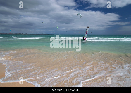 Planche à voile et kite surfeurs sur les Grandes Playas Beach sur l'océan Atlantique, Fuerteventura, Îles Canaries, Espagne. Banque D'Images