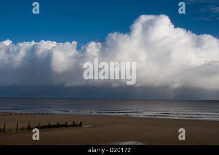 Le soleil brille sur la plage de sable de Frinton and-on-sea, Essex tandis que des nuages de pluie sont à quelques milles en mer Banque D'Images