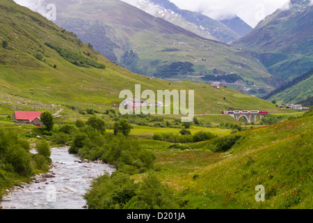 Vallée d'Urseren avec river Furkareuss, train Glacier Express à l'arrière-plan Andermatt, Uri, Suisse Banque D'Images