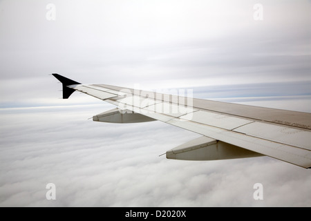 Vol d'un avion à travers les nuages gris Banque D'Images