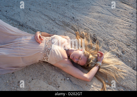 Woman lying in dry river run dans une belle robe. Banque D'Images