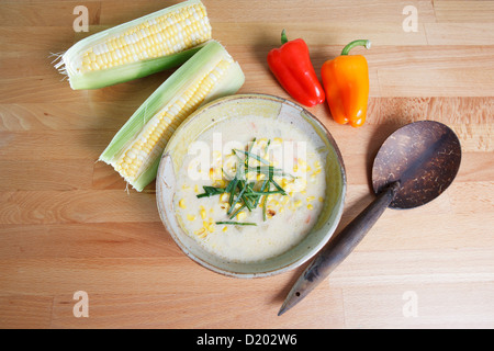 Soupe Chaudrée de maïs style sud-ouest toute garnie avec des épis de maïs et des poivrons de couleur Banque D'Images